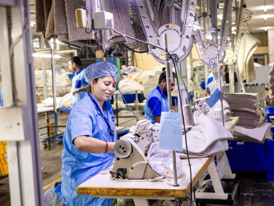 Garment factory workers operating industrial sewing machines
