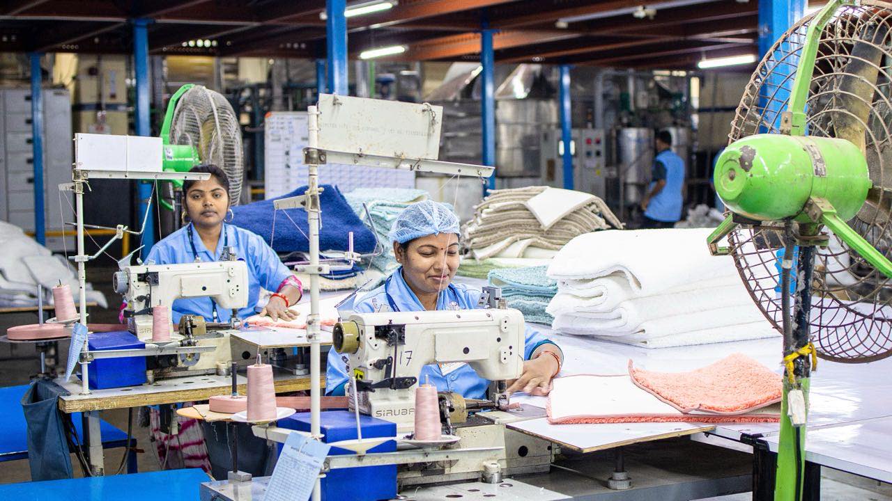 Machine operators sewing on the production line of an apparel factory