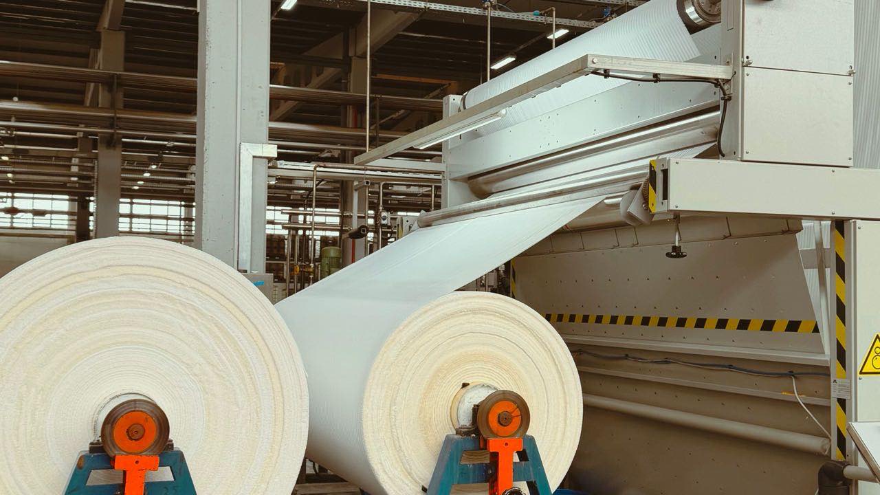Rolls of finished fabric on a textile mill floor