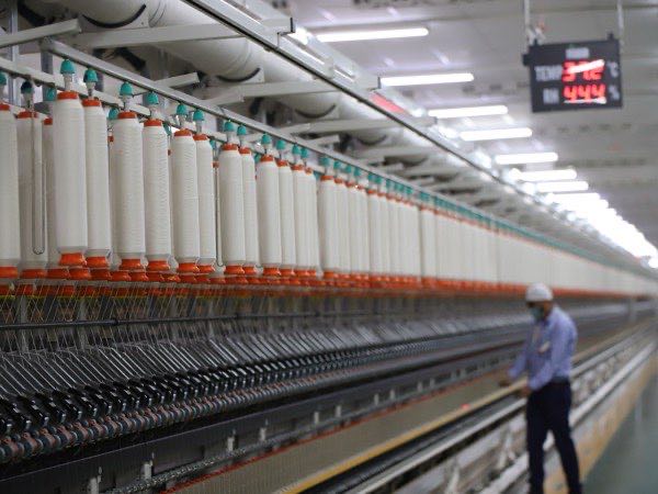 Textile mill machinery running yarn during fabric production