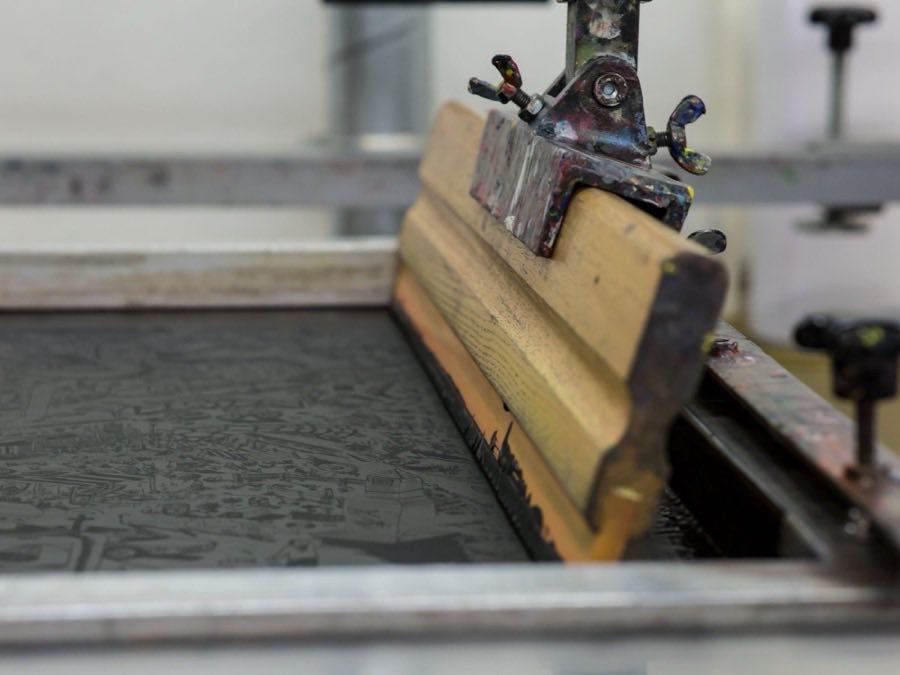 Screen printing being applied to garment panels