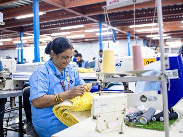 Machine operator sewing a garment on an industrial machine
