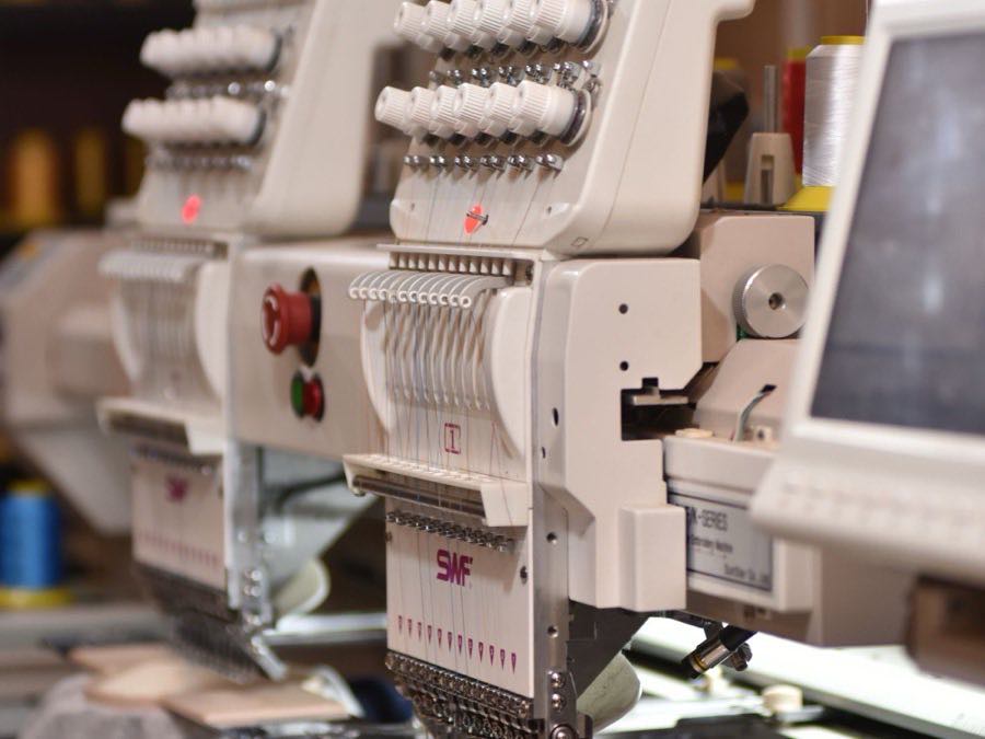 Industrial embroidery machine running a garment placement