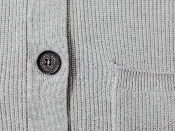Close-up of a knitted cardigan showing stitch and button detail